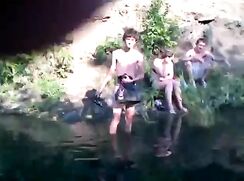 Cute boy with a sexy ass is swimming in the lake with friends