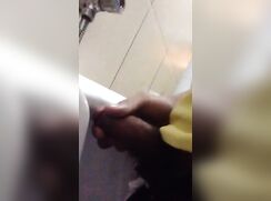 Boy jerking at urinal is being watched