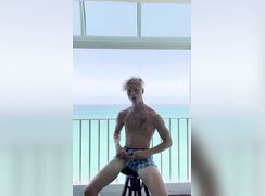 Skinny blond hunk jerking off on the hotel balcony