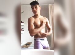 Latino muscle boy flexes and strips
