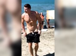 Man takes off swimming trunks on a beach