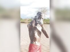 Black twink bathing in the river with semi hard dick