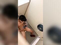 Spy on Straight Asian boy in cubicle wanking watching porn on phone