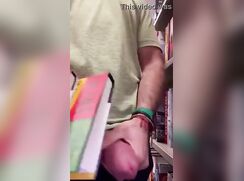 College boy with a thick cock beats off in the library on campus