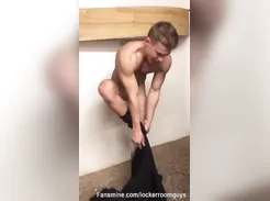 Handsome young surfer is filmed by his friend in the locker room