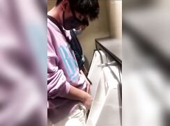 A male is pissing in the toilet 2