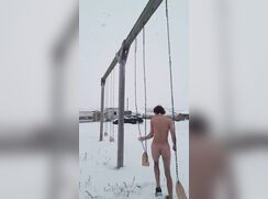Cute boy swinging naked outside.