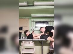 Blowing his military buddy on a table