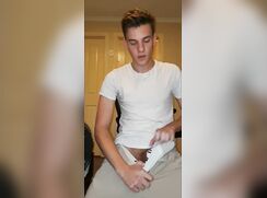Hung uncut boy in white shirt reveals his cock, wanks and cums
