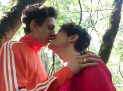 Two young boys fooling around and sucking each other in the wood