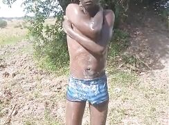 Black twink bathing outdoor with hard dick