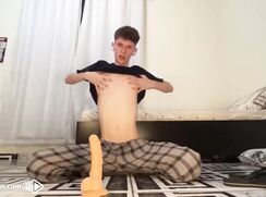 Twink rides a dildo while he jerks his big cock