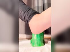 Chastity boy rides a big green dildo