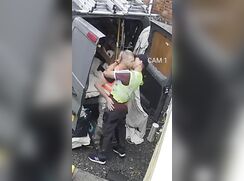 2 Construction workers fool around behind the work van while grabbing supplies.