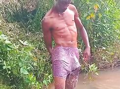 Black twink bathing outdoor with semi hard dick