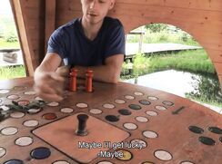 CH 632, Camera guy pays a young guy in a blue T sitting by a gaming board in a wooden