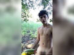 Menino comendo mamão papaia no mato