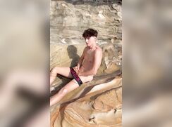 Sven jerks off on the rocks, being seen