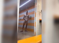 Muscle boy in the locker room shower