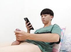 Asian college boy checking out some porn on his phone