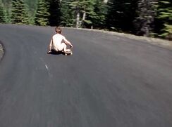 AI Naked skateboarder rides downhill